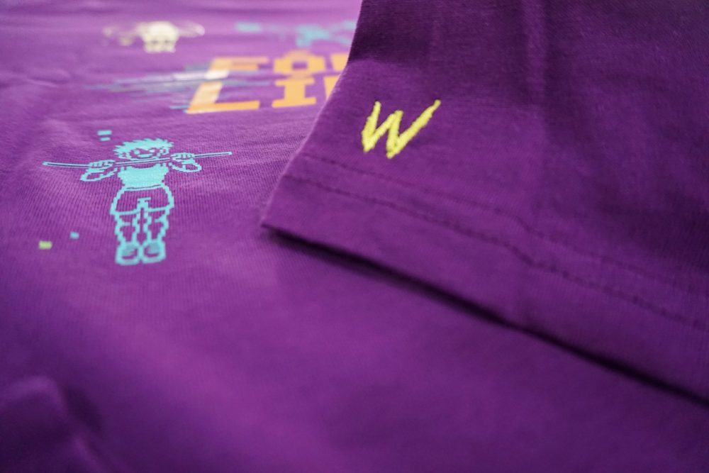 detalle bordado amarillo en camiseta de algodón morada con diseño respawn