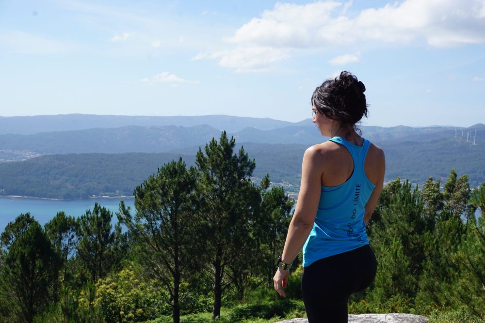 chica mirando el paisaje desde la cima de la montaña